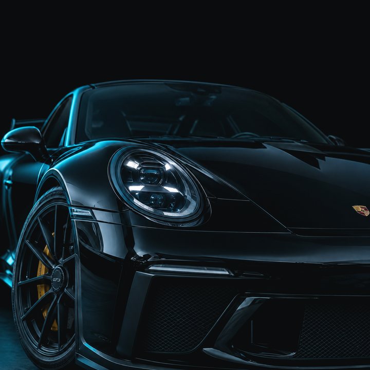 Front view of a black sports car in a dark studio